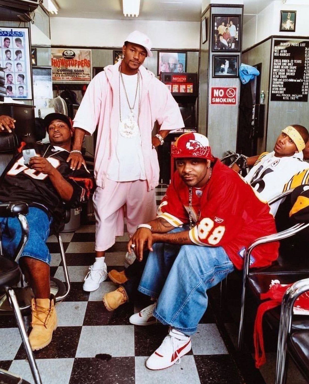 Three men posing in a barbershop wearing colorful oversized streetwear and jerseys.