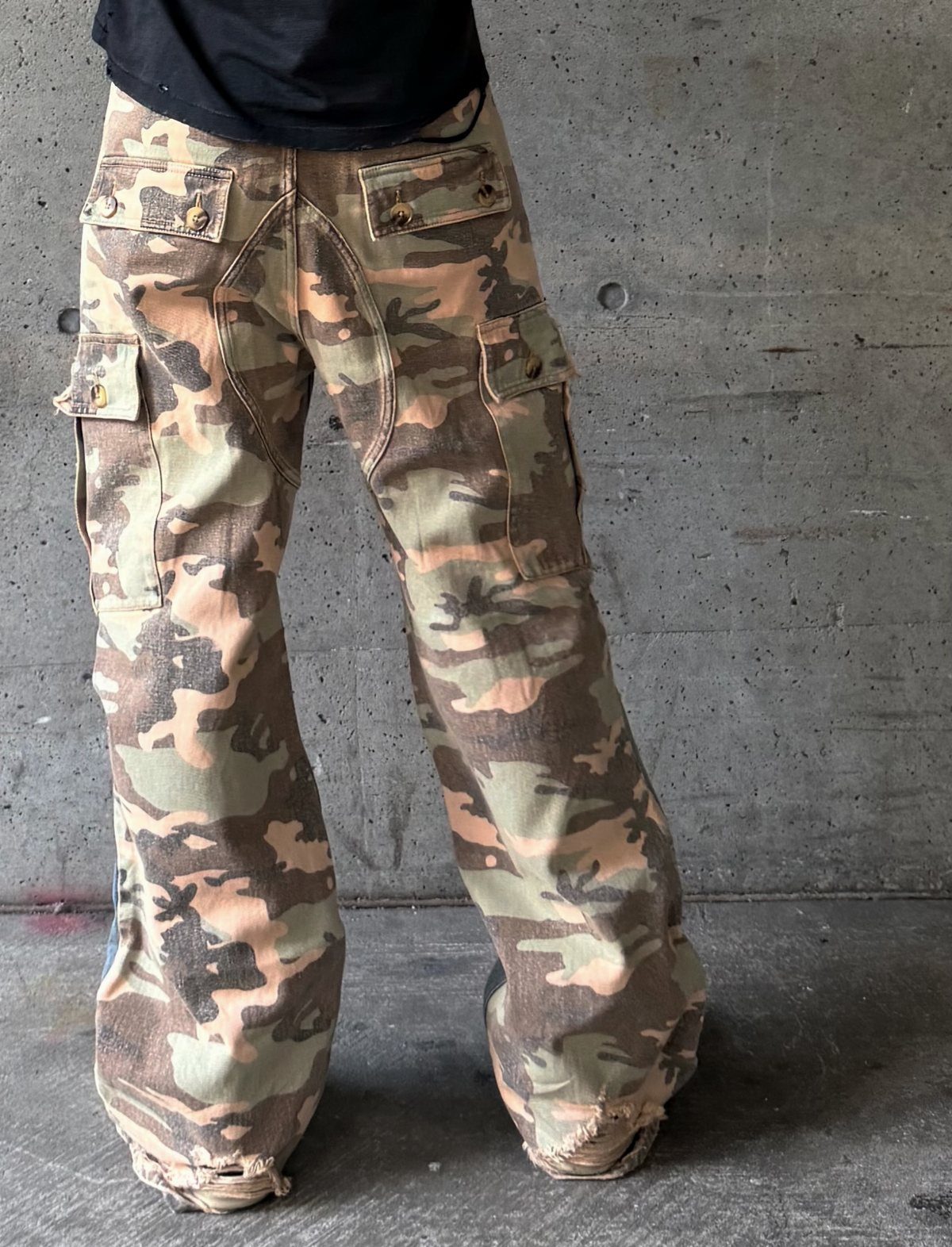 Camouflage cargo pants with a baggy fit and frayed hems worn by a person.