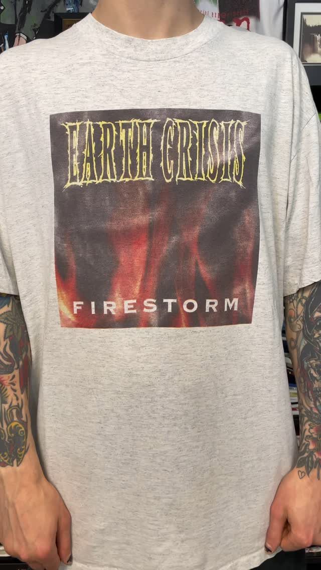 A person wearing a grey Earth Crisis Firestorm vintage band t-shirt with graphic print.