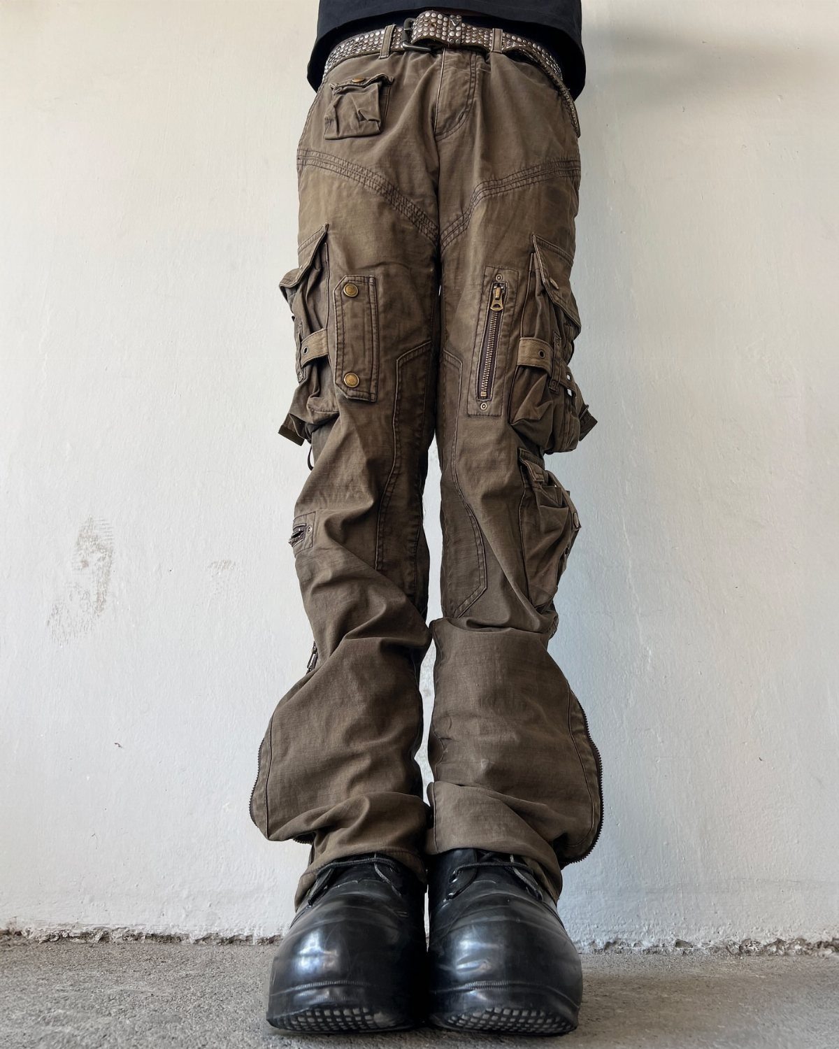 Person wearing brown utility cargo pants with large pockets and black leather shoes.