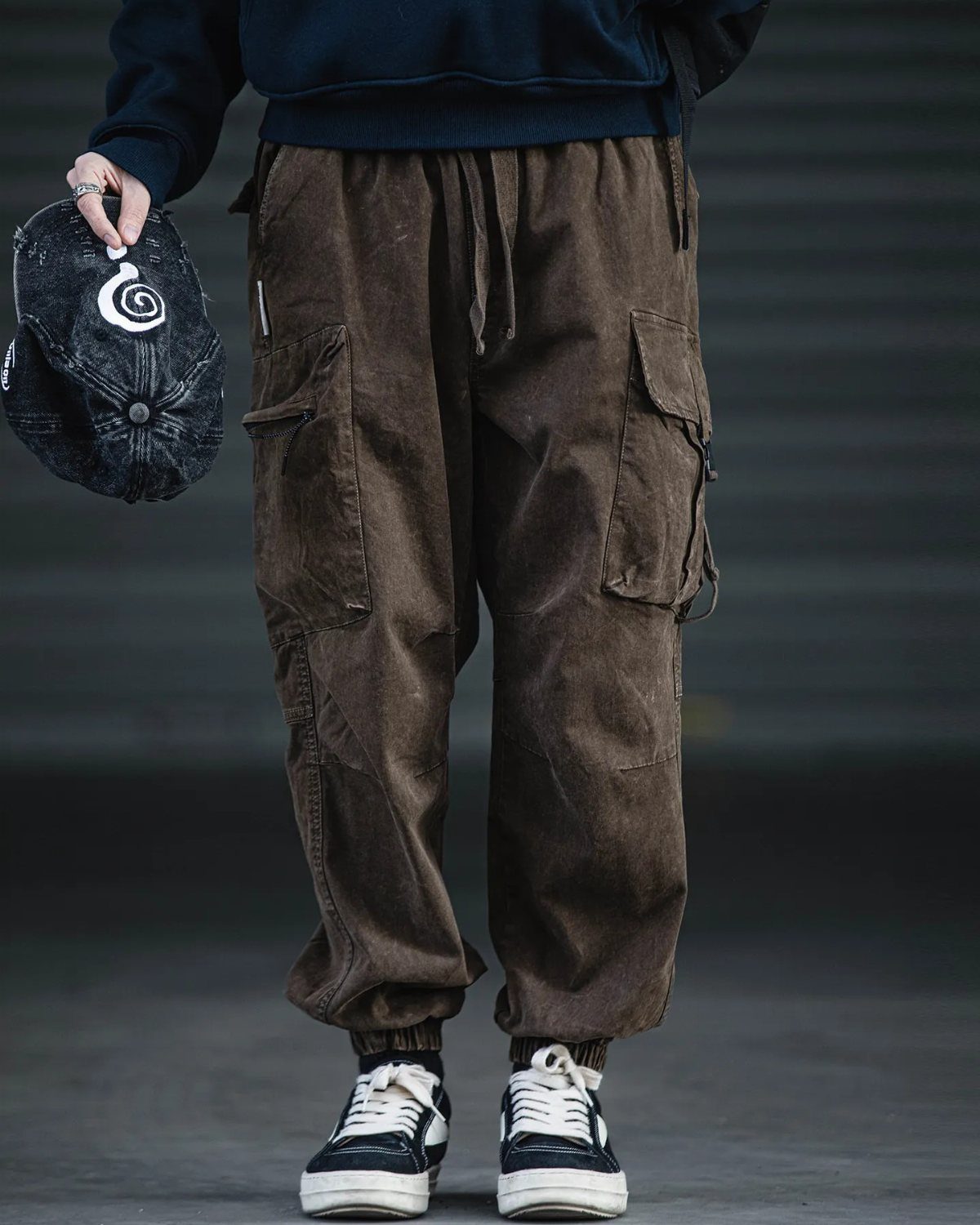 Person wearing brown relaxed cargo pants with large pockets and black sneakers.