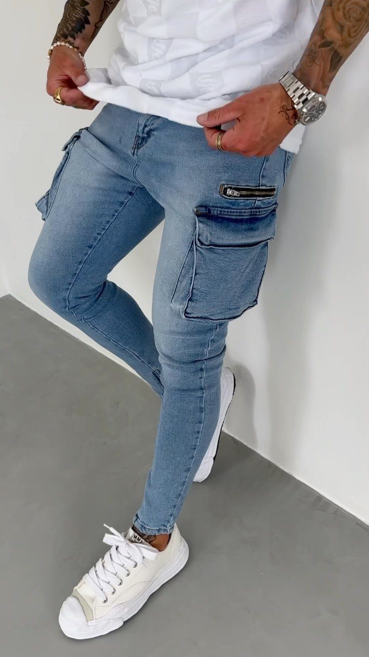 Person wearing light blue slim-fit denim cargo pants with large pockets and white sneakers.