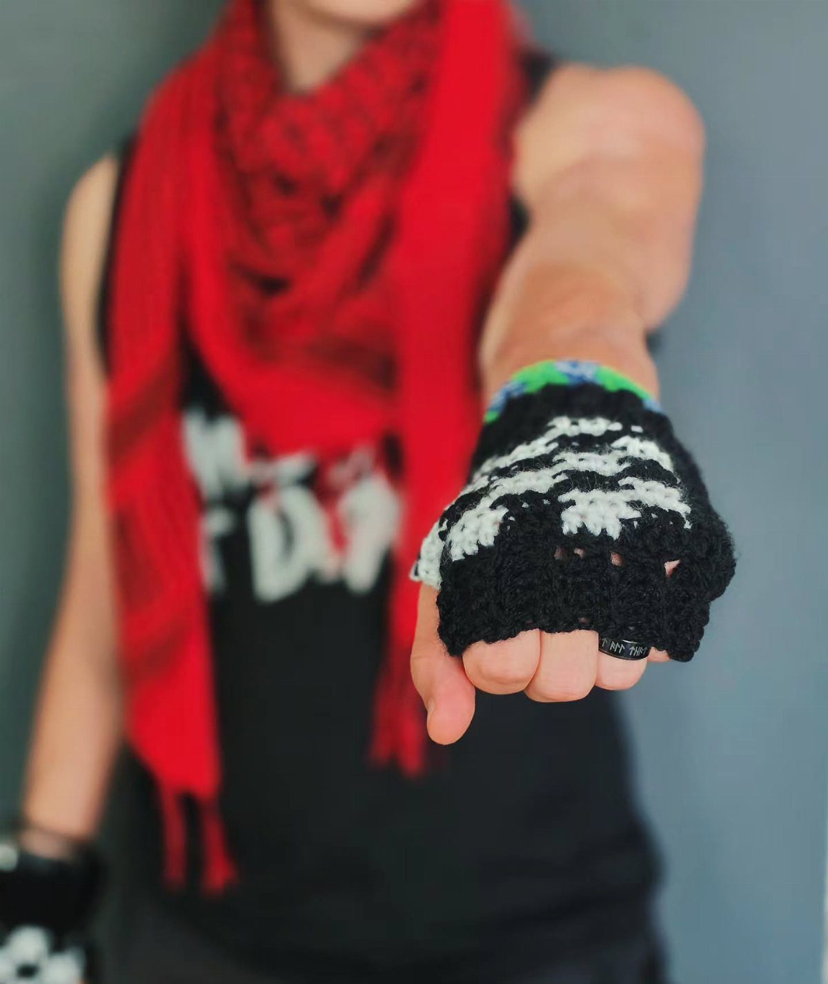A hand wearing a black and white crocheted fingerless glove extended toward the camera.