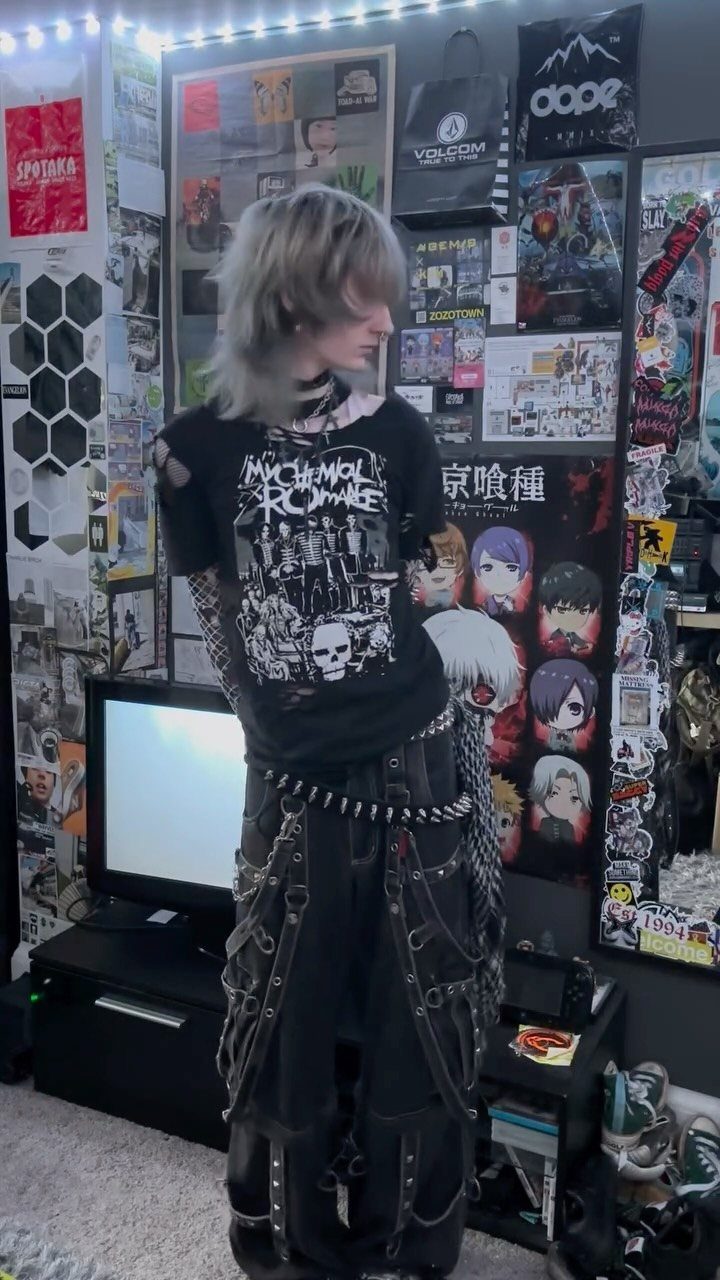 A person wearing an emo aesthetic outfit with chains, studs, and a graphic t-shirt.