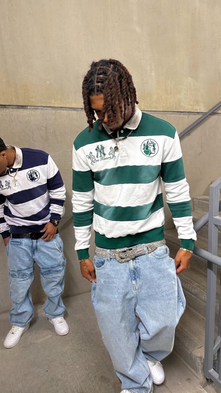 Two men wearing oversized striped polo shirts and baggy light-wash denim jeans.