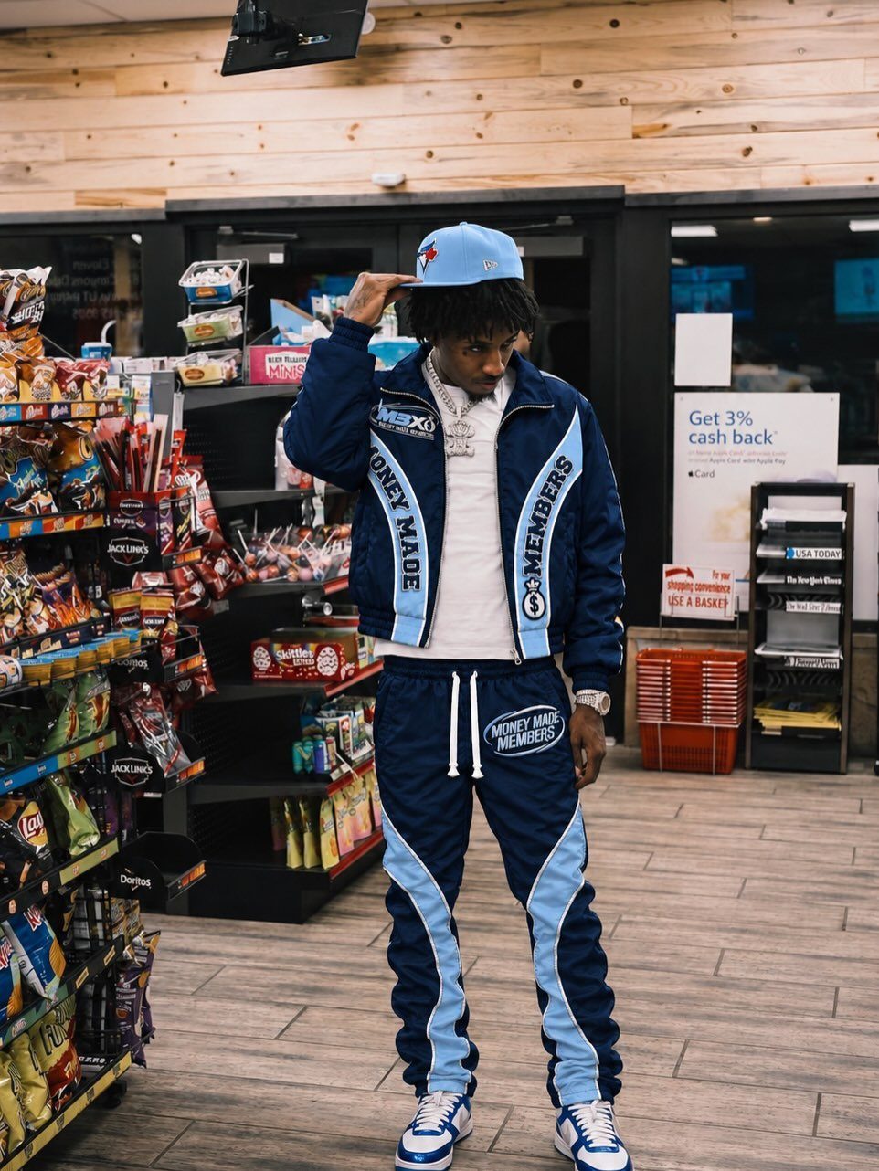 A person wearing a navy and light blue windbreaker jacket and matching track pants.