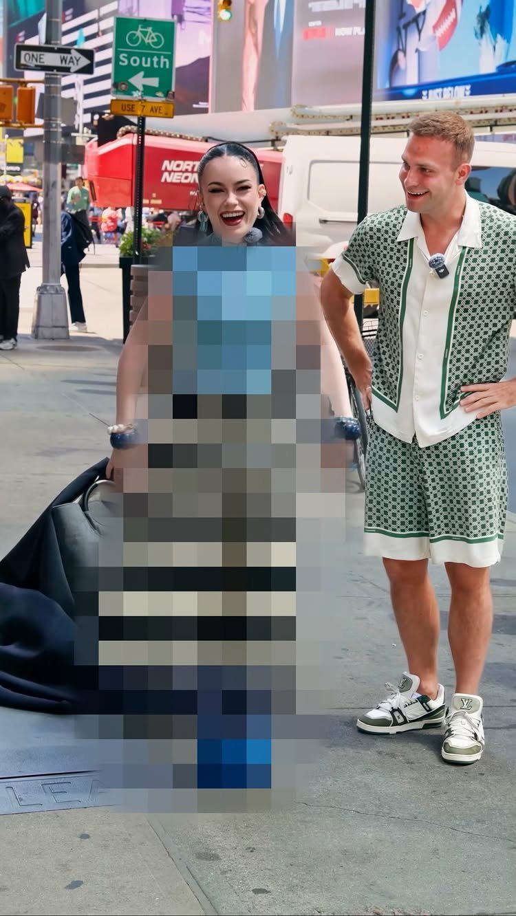 A woman laughing and a man in matching green patterned summer attire standing on a New York street.