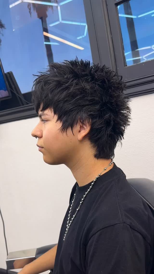 A person with short, spiky, layered black hair shown in a side profile view.