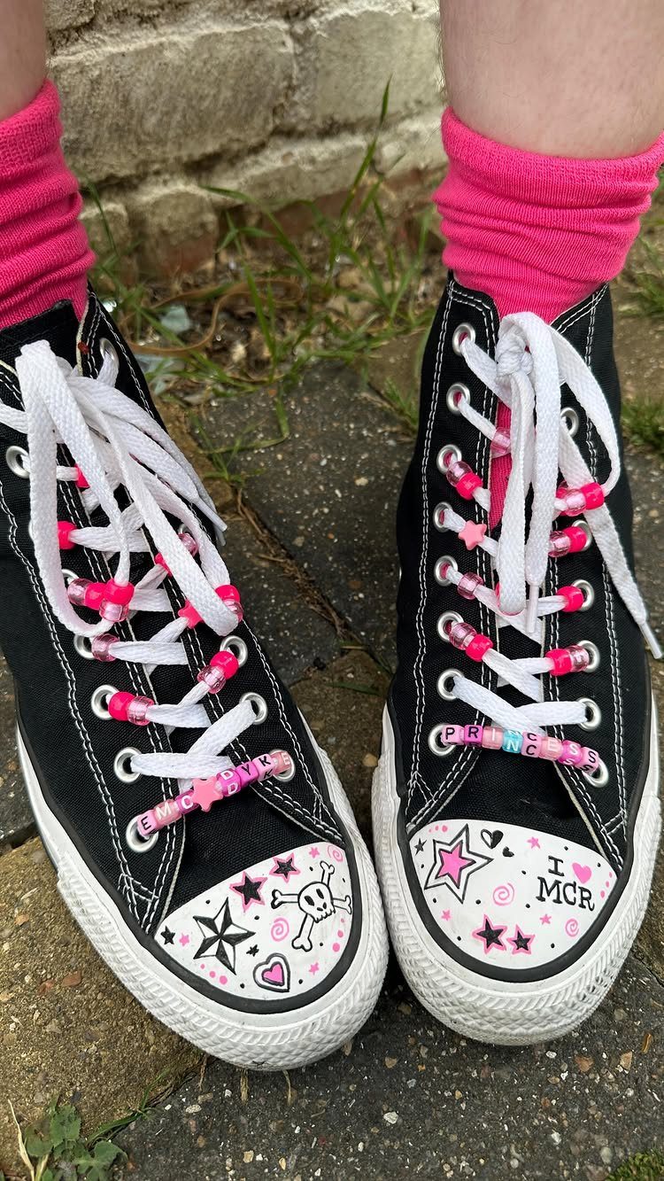 Black high-top sneakers decorated with pink beads and white hand-drawn emo-style illustrations.