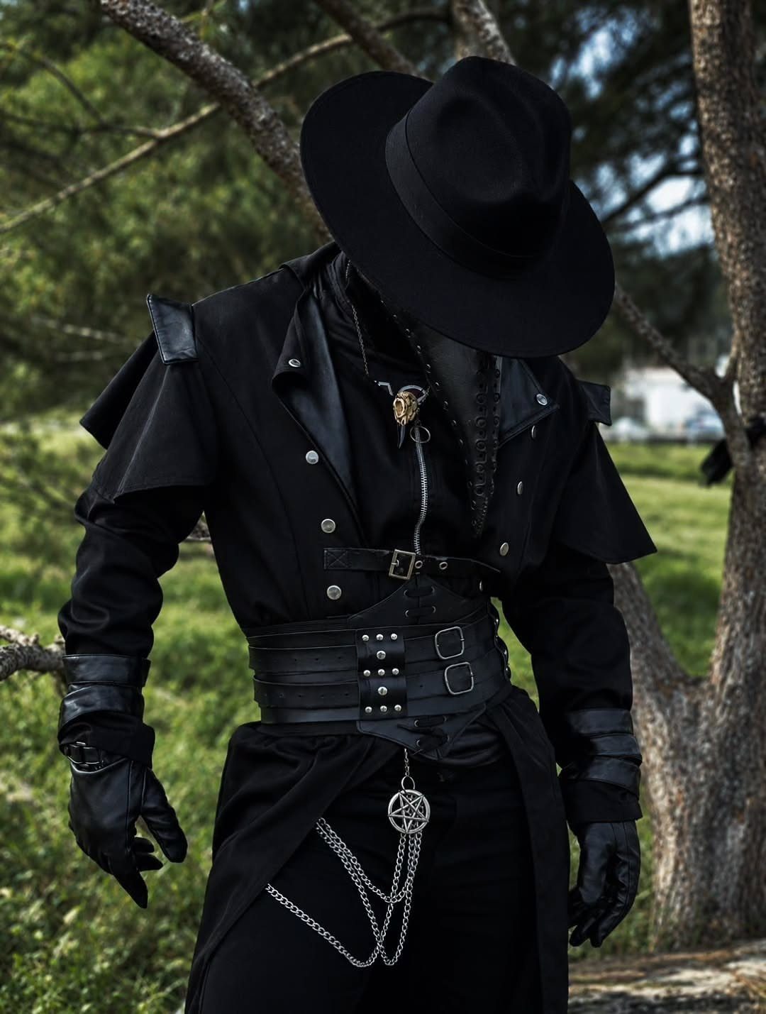 Person wearing an elaborate black gothic costume with a wide-brimmed hat and leather corset belt.