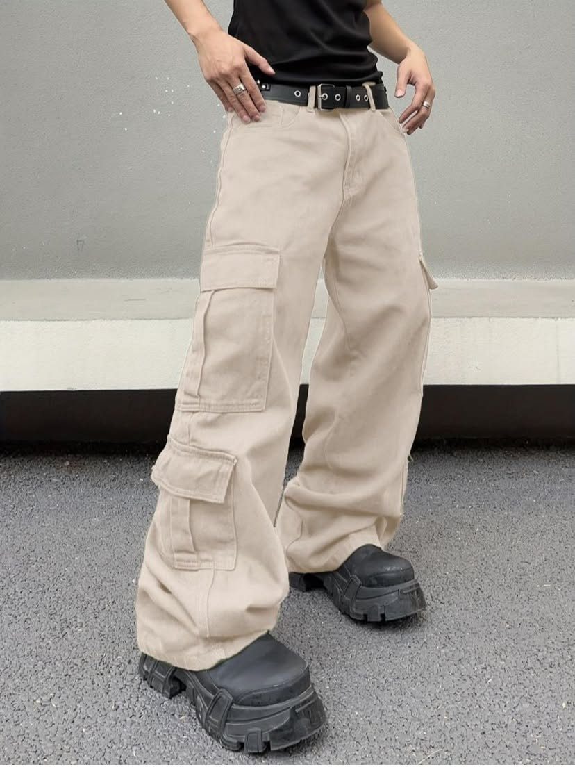 Person wearing baggy beige cargo pants with large pockets and chunky black platform boots.