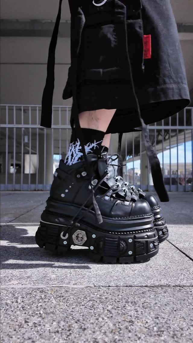 Black chunky platform boots with heavy soles and silver hardware worn with graphic socks.