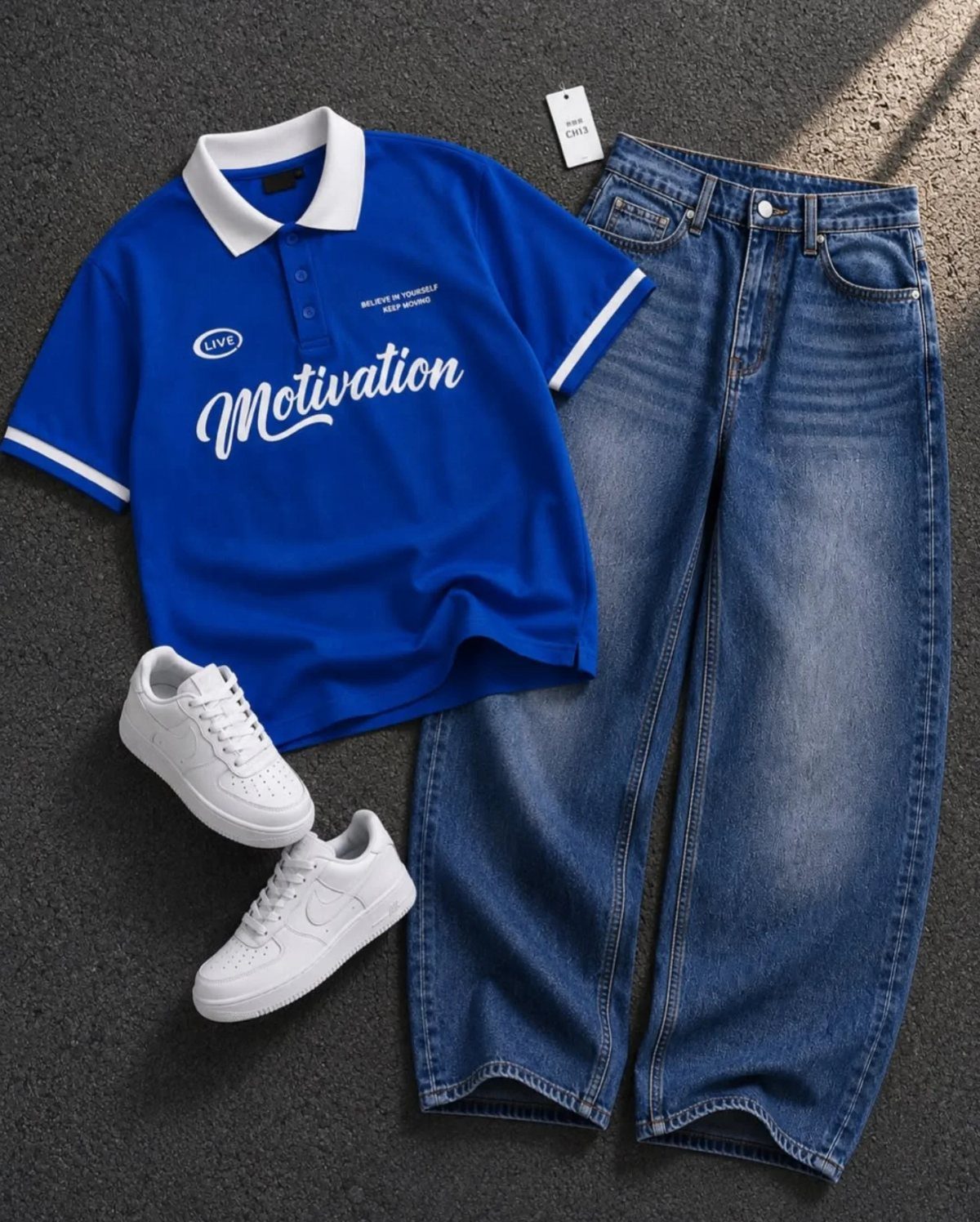 Blue polo shirt with white text, blue wide-leg jeans, and white sneakers on a dark background.